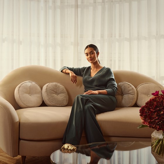 Woman sitting on the sofa of the Mews Terrace Suite